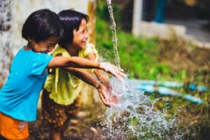 Children play water tap sprinkler