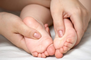 Woman massaging a child's foot
