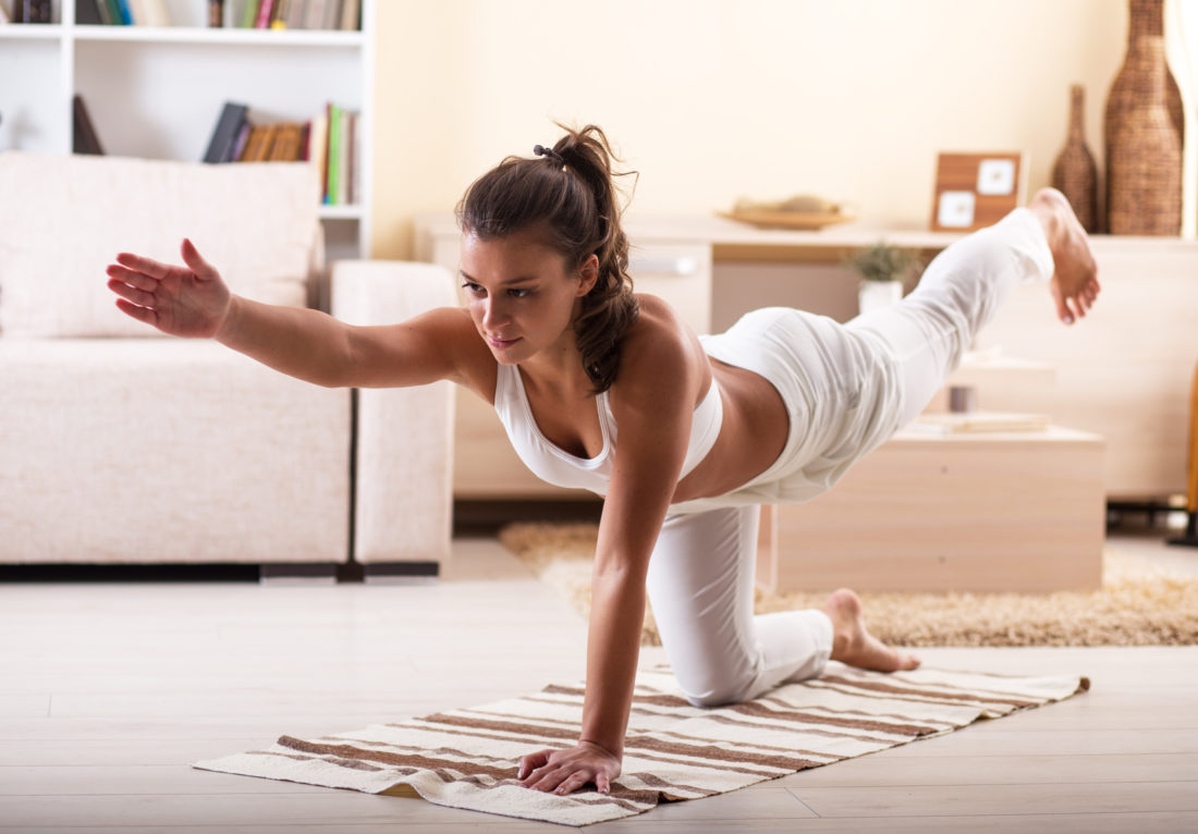 woman doing a yoga pose at home